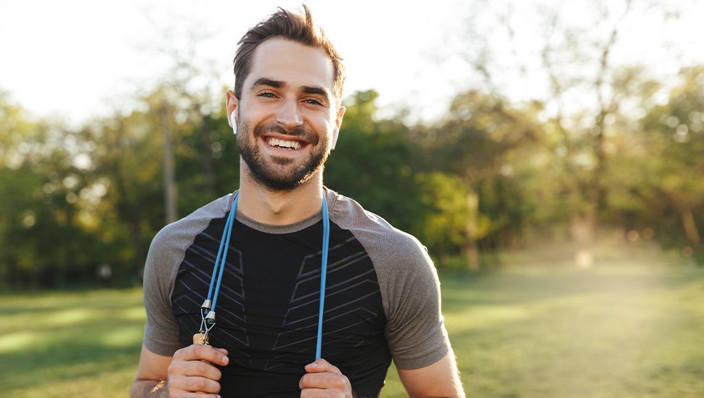 Younger Male Model Smiling while Exercising Outside