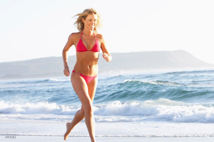 Female in red bikini running on beach