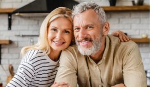 Older Female and Male Models embracing in the kitchen